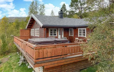 a log cabin with a hot tub on the deck at Lovely Home In Bjorli With Wifi in Bjorli