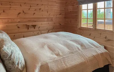 a bedroom with a bed in a log cabin at Lovely Home In Bjorli With Wifi in Bjorli
