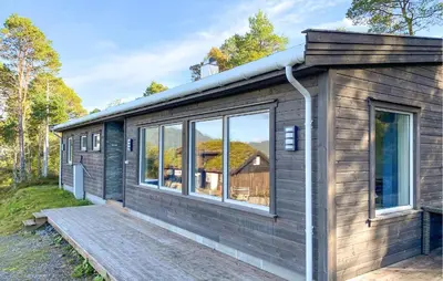 a small house with a deck and windows at 3 Bedroom Beautiful Home In Torvikbukt in Torvikbukt