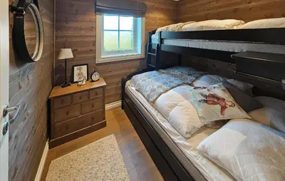 a bedroom with two bunk beds in a log cabin at 5 Bedroom Nice Home In Edland in Vågsli