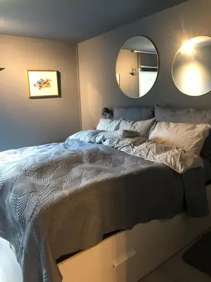 a bedroom with a large bed and a mirror at Koselig rekkehus med tre soverom in Trondheim