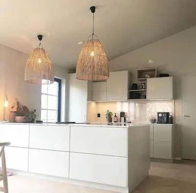 a kitchen with white cabinets and two pendant lights at Vakreste plass og beliggenhet! in Trondheim