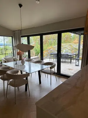 a living room with a table and chairs and a large window at Vakreste plass og beliggenhet! in Trondheim