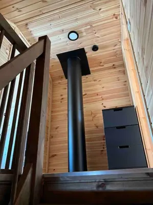 a spiral staircase with a clock in a wooden ceiling at Delikat tømmerhytte på Blefjell in Flesberg