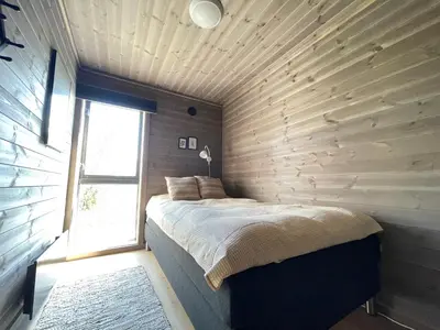 a bedroom with a bed in a wooden wall at Bjørkebo in Ål - cabin in hiking and skiing area in Ål