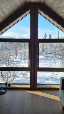 a room with a large window with snow outside at Bjørkebo in Ål - cabin in hiking and skiing area in Ål