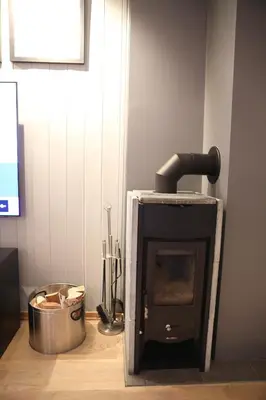 a fireplace in the corner of a room with a bucket at Ledig vinterferien er en stor ski in out leilighet med panoramautsikt over Hemsedal in Hemsedal