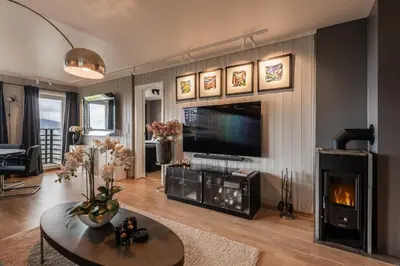 a living room with a fireplace and a flat screen tv at Ledig vinterferien er en stor ski in out leilighet med panoramautsikt over Hemsedal in Hemsedal