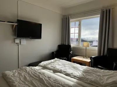 a hotel room with a bed and a flat screen tv at Bitihorn hotellfølelse i sentrum in Beitostøl