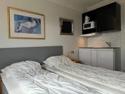 an unmade bed in a room with a microwave at Bitihorn hotellfølelse i sentrum in Beitostøl
