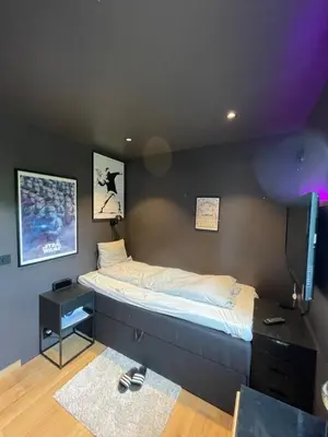 a bed in a room with a black wall at Leilighet på to plan nyoppusset sentralt på Tyholt Trondheim in Trondheim