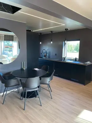a kitchen and dining room with a black table and chairs at Leilighet på to plan nyoppusset sentralt på Tyholt Trondheim in Trondheim