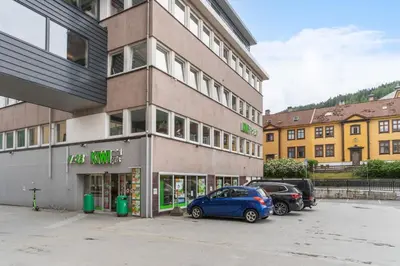 a blue car parked in front of a building at Sentral leilighet med parkering og peis in Bergen