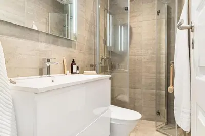 a bathroom with a toilet and a sink and a shower at Sentral leilighet med parkering og peis in Bergen