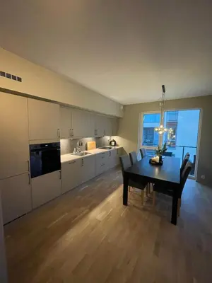 a kitchen with a table and a dining room at Splitter ny, romslig leilighet sentralt på Nyhavna leies ut in Trondheim