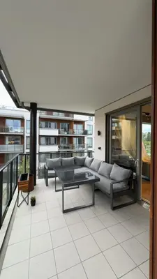 a living room with a couch and a table on a balcony at Splitter ny, romslig leilighet sentralt på Nyhavna leies ut in Trondheim