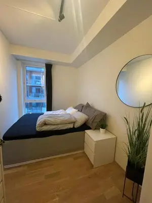 a small bedroom with a bed and a window at Splitter ny, romslig leilighet sentralt på Nyhavna leies ut in Trondheim