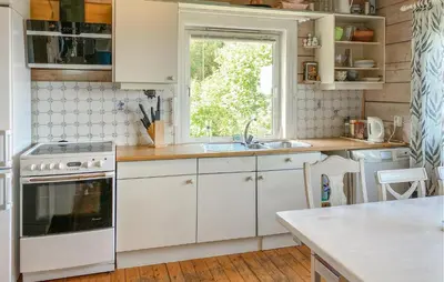 a kitchen with white cabinets and a sink and a window at Nice Home In Farstad With Wifi in Farstad