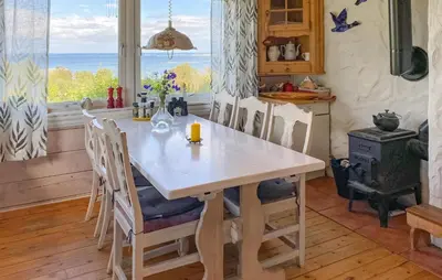 a kitchen with a table and chairs with a view of the ocean at Nice Home In Farstad With Wifi in Farstad