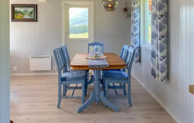 a blue dining room table with blue chairs and a window at 3 Bedroom Stunning Home In Fiksdal in Fiksdal
