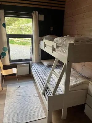 two bunk beds in a room with a window at Moderne hytte Sjusjøen in Sjusjøen