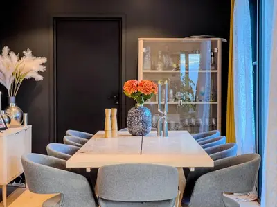 a dining room table with chairs and a vase with flowers at Ski VM 2025 Eksklusivt hus in Trondheim