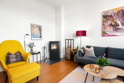 a living room with a couch and a yellow chair at Sentral og stilfull leilighet in Bergen