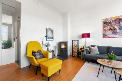 a living room with a couch and a yellow chair at Sentral og stilfull leilighet in Bergen