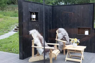 two chairs with faux fur sitting on a patio at Glimre Romsdal - Eksklusivt speilhus ved Åndalsnes in Isfjorden