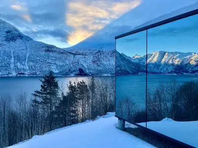 a room with a view of a lake and mountains at Glimre Romsdal - Eksklusivt speilhus ved Åndalsnes in Isfjorden