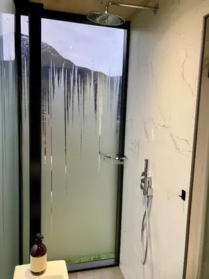 a shower with a glass door in a bathroom at Glimre Romsdal - Eksklusivt speilhus ved Åndalsnes in Isfjorden
