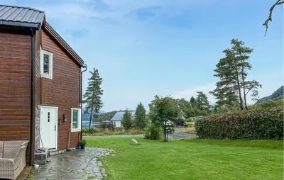 a dog sitting in the grass next to a building at Beautiful Home In Skodje in Vatne