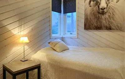 a bedroom with a bed and a picture of a sheep at Beautiful Home In Skodje in Vatne