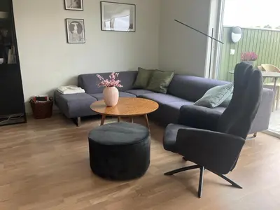 a living room with a couch and a table and chairs at Heimdal Sentrum in Heimdal