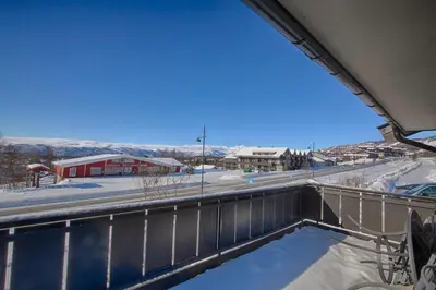 a view from the balcony of a building in the snow at Perfect Family Base In Beitostølen in Beitostøl