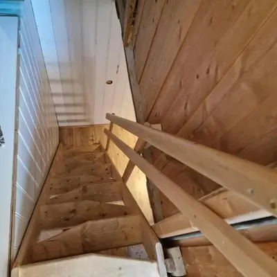 an attic room with wooden walls and wooden stairs at Captivating 6-Bed Cottage in Lismarka in Haugen