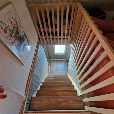 a staircase in a house with a wooden railing at Captivating 6-Bed Cottage in Lismarka in Haugen