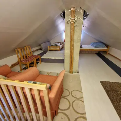 a living room with a couch and chairs in a attic at Captivating 6-Bed Cottage in Lismarka in Haugen