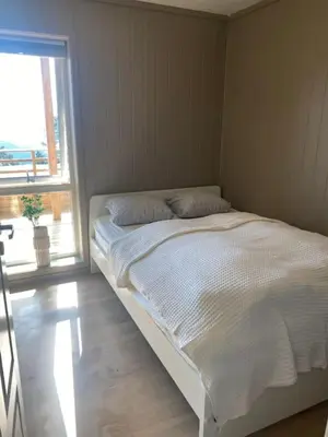 a white bed in a room with a window at Oppgradert leilighet i Tråstølen in Skulestadmo