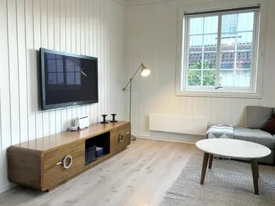 a living room with a flat screen tv on the wall at Sentral og koselig leilighet! in Lillehammer