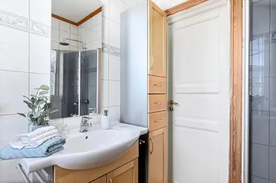 a white bathroom with a sink and a mirror at Sentral og koselig leilighet! in Lillehammer