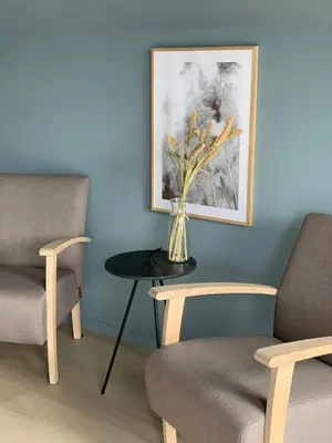 a vase of flowers on a table next to two chairs at Måløy Fjordbuer moderne og luksuriøse med havutsikt in Måløy