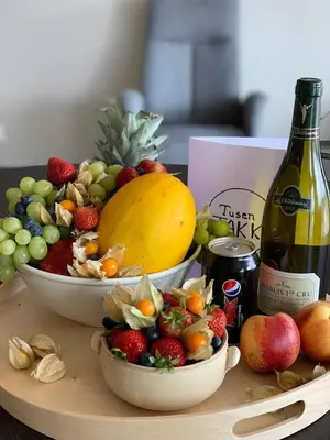 two bowls of fruit on a table with a bottle of wine at Måløy Fjordbuer moderne og luksuriøse med havutsikt in Måløy