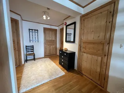 a room with a wooden door and a chair at Stylish And Spacious Apartment In The Heart Of Beitostølen in Beitostøl