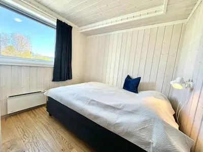 a bedroom with a large bed with a window at Modern apartment in the heart of Geilo center in Geilo