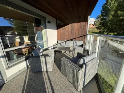 a balcony with wicker chairs and a table on a patio at Modern apartment in the heart of Geilo center in Geilo
