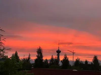 a sunset with a tv tower in the background at Trondheim- free parking in Høiset