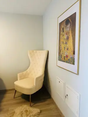 a white chair in a room with a painting at Trondheim- free parking in Høiset