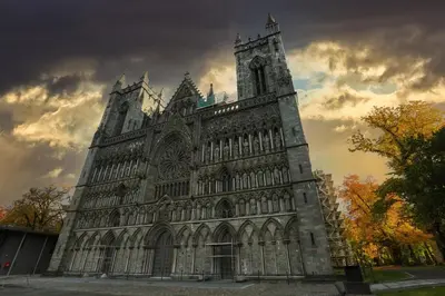 a large building with a clock tower on a cloudy sky at Apartment Solsiden Trondheim in Trondheim