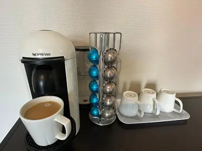 a counter with a coffee maker and a cup of coffee at Apartment Solsiden Trondheim in Trondheim